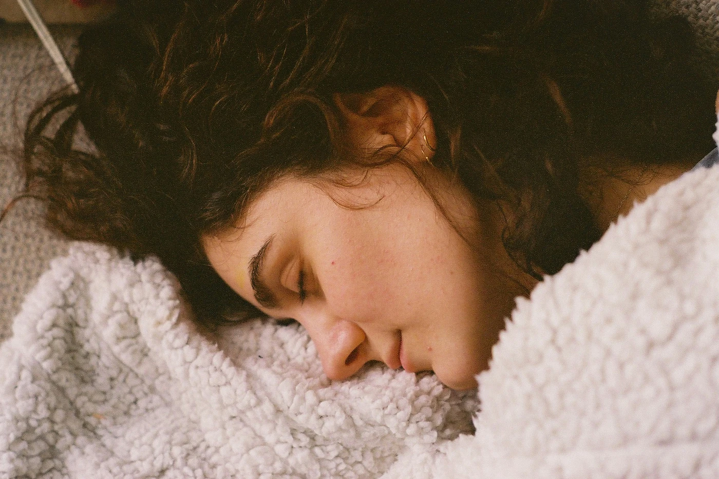 glasses and hands on a bed