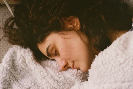 glasses and hands on a bed